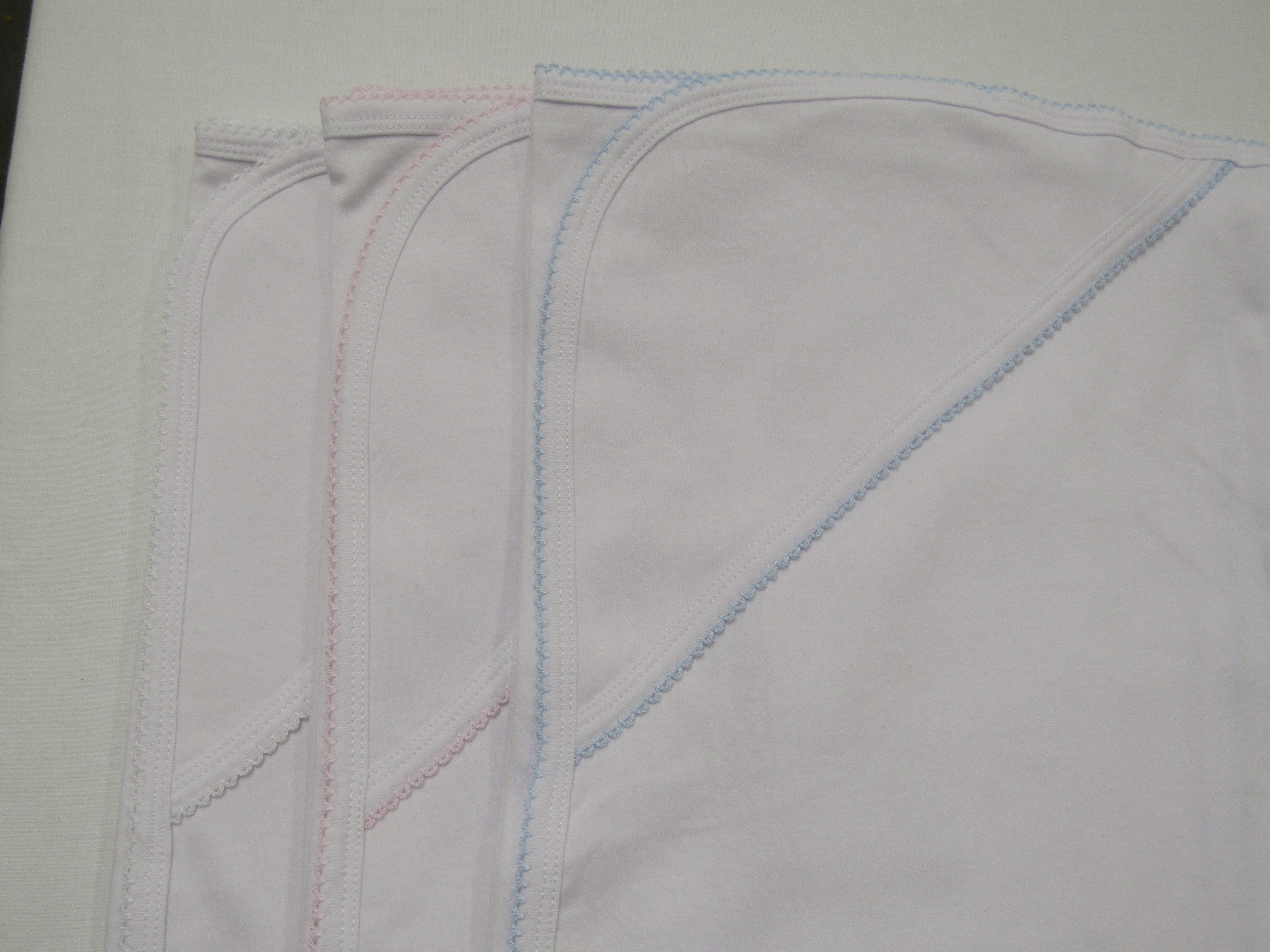 Cotton knit hooded baby towels in white, pink, and blue trim
